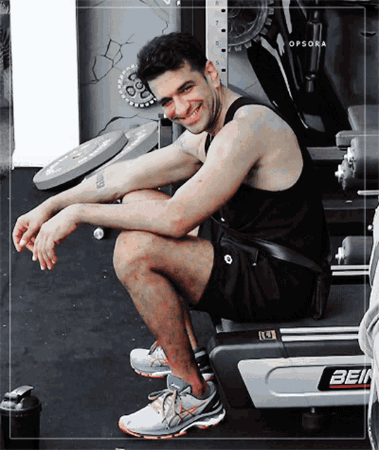 a man is sitting on a treadmill with the letters bein on it