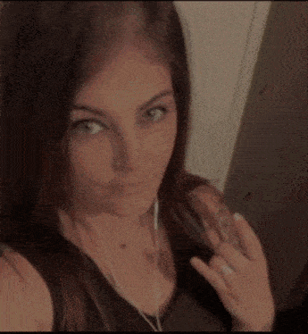 a woman wearing headphones and a ring takes a picture of herself