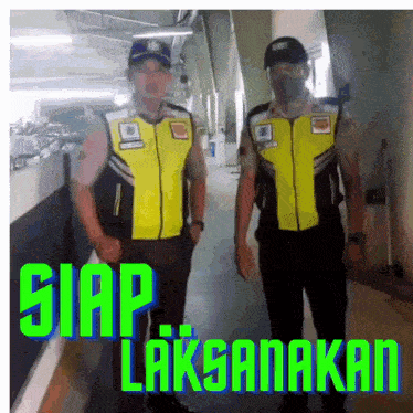 two security guards are standing next to each other in a hallway with the words siap laksanakan written in green letters