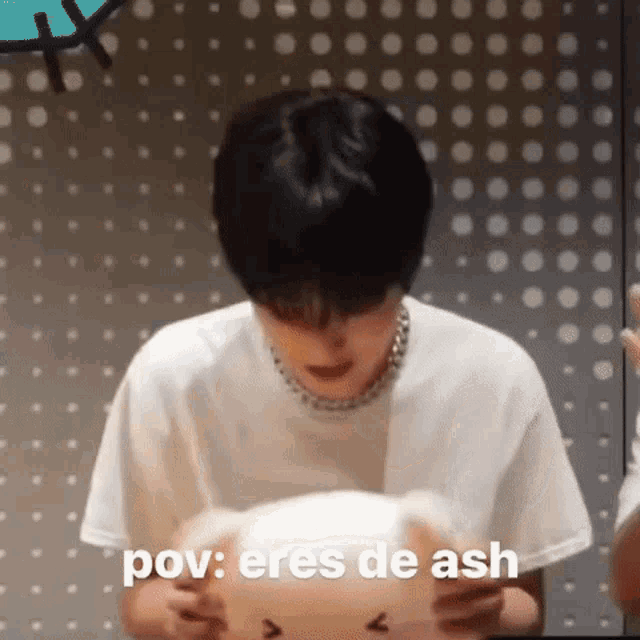 a man in a white shirt is holding a stuffed animal and saying pov : eres de ash .