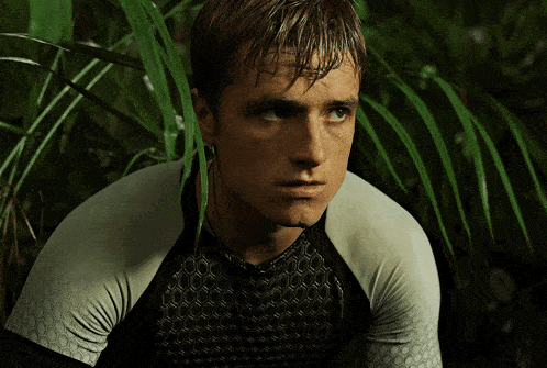 a close up of a man 's face surrounded by green plants