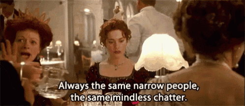 a woman in a red dress is sitting at a table with a lamp and a quote from the movie titanic .