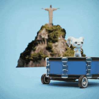 a toy rabbit is sitting on top of a drum in front of a statue of jesus