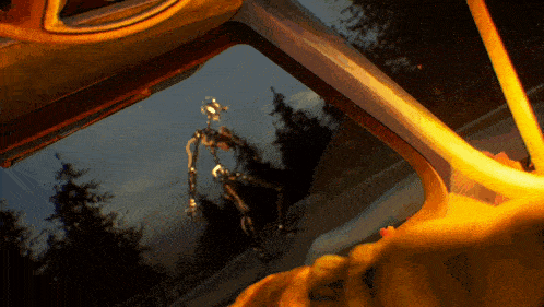 a person looking out a car window with a skeleton in the background