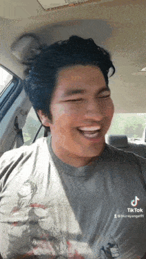 a man is laughing while sitting in a car .
