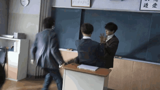 a group of people standing in front of a chalkboard with chinese writing on it