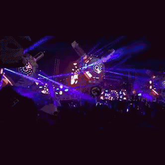 a man wearing a hat with the letter b on it is dancing in a crowd of people