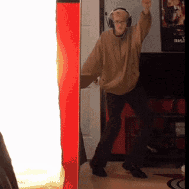 a man wearing headphones dancing in a room