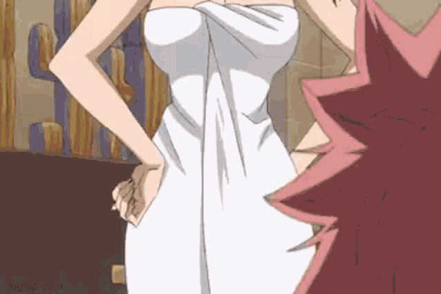 a woman wrapped in a towel is standing next to a man .