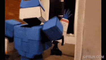 a gif from gifrun.com shows a blue robot standing in a room