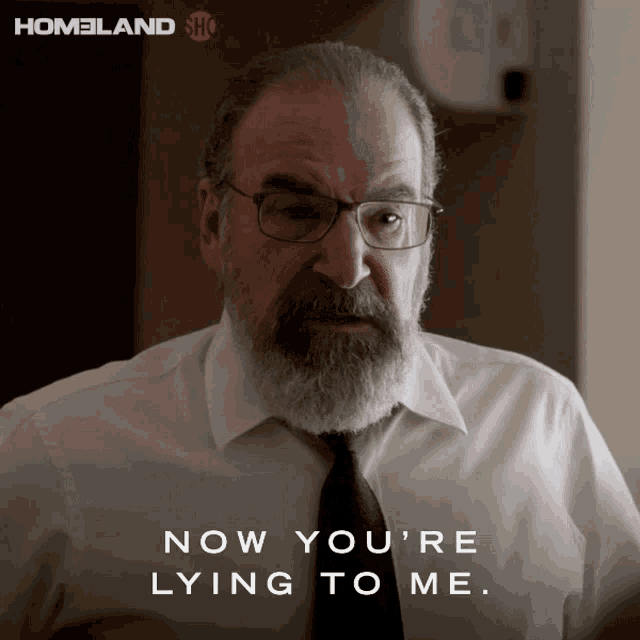 a man with glasses and a beard has the words now you 're lying to me above him