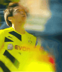 a blurry picture of a soccer player wearing a yellow jersey with the word evo on it