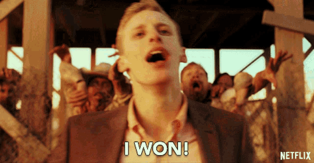 a man in a suit says i won in front of a crowd