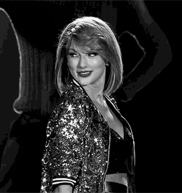 a black and white photo of a woman in a sequined jacket .