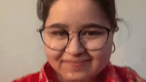 a close up of a woman wearing glasses making a face