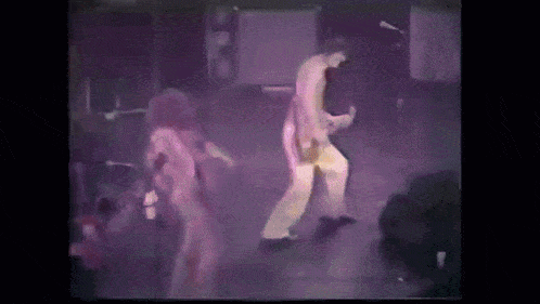 a man and woman are dancing on a stage in front of a crowd .
