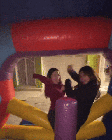 two girls are playing in an inflatable castle