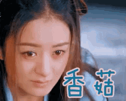 a close up of a woman 's face with chinese writing behind her .