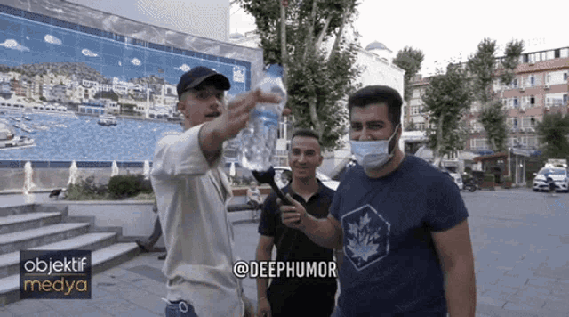 a man wearing a mask is pointing at something in front of a building that says objektif medya