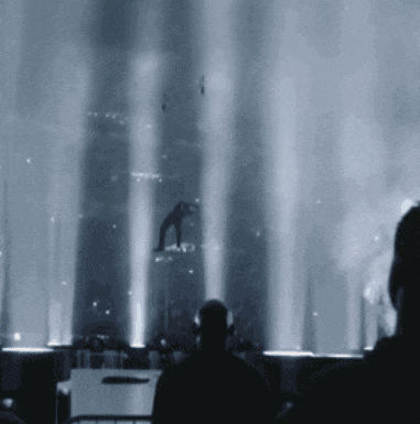 a man is standing in front of a stage with a bunch of lights behind him