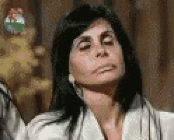 a woman is making a funny face with her eyes closed while wearing a white jacket .