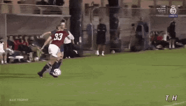 two women are playing soccer on a field with the word trophy on the bottom right