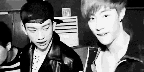 two young men are standing next to each other in a room .