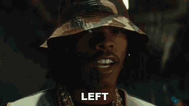 a close up of a man wearing a bucket hat with the word left below him