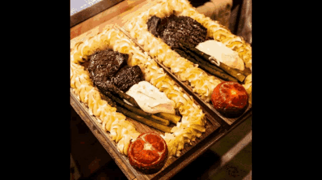 two plates of food with asparagus and mashed potatoes on a table