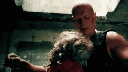 a man is holding a woman in a dark room .