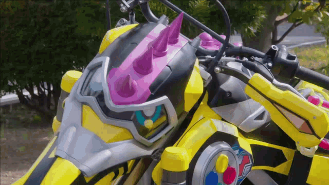 a yellow motorcycle with pink spikes on the front