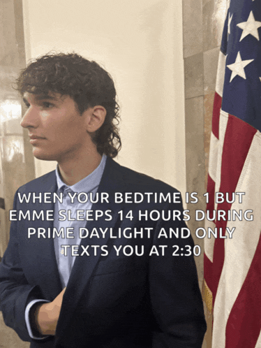 a man in a suit is standing in front of an american flag and says when your bedtime is 1 but emme sleeps 14 hours