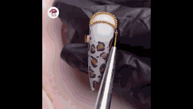 a close up of a person 's nails with a leopard print and a ring .