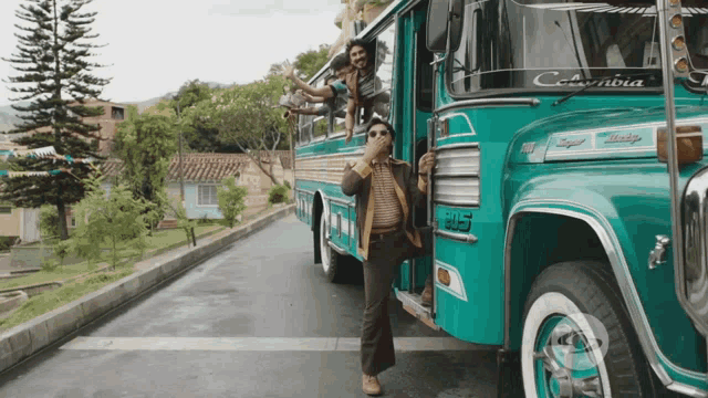 a man is standing in front of a bus that says columbia on the front