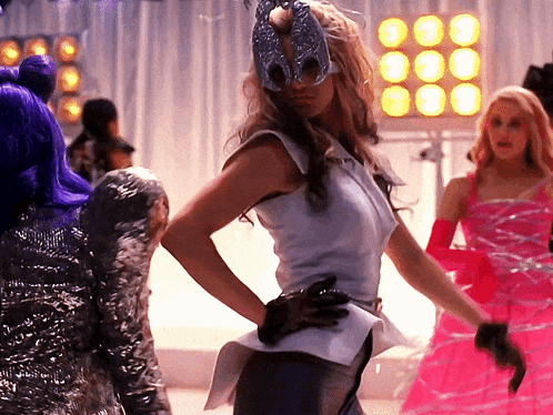 a woman wearing a mask and gloves is dancing in a room