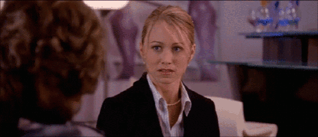 a woman in a suit and pearls talks to another woman