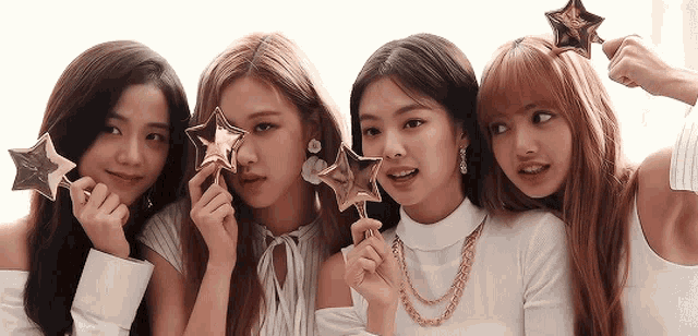 a group of girls are posing for a picture and holding stars in their hands
