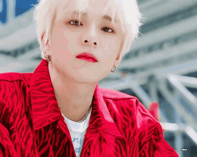 a close up of a young man wearing a red shirt