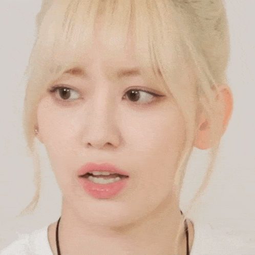 a close up of a blonde woman 's face with a necklace around her neck