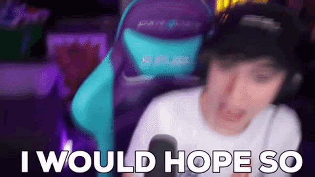 a man wearing headphones and a hat is sitting in a gaming chair .