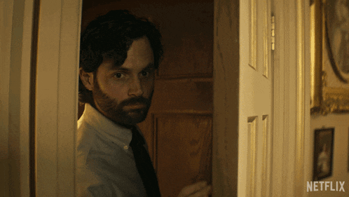 a man standing in a doorway with netflix written on the bottom right