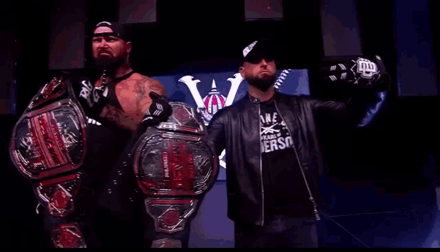 two wrestlers standing next to each other with one wearing a shirt that says ' me ' on the front