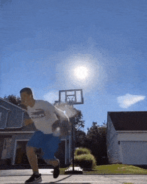a man wearing a shirt that says ' abercrombie & fitch ' on it is jumping in the air