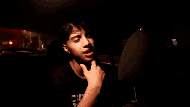 a young man sitting in a car with a t-shirt that says ' e.u. ' on it