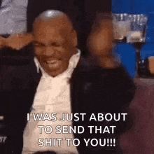 mike tyson is smiling and laughing while sitting in a audience .