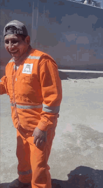 a man wearing an orange jumpsuit with a reebok logo on his chest
