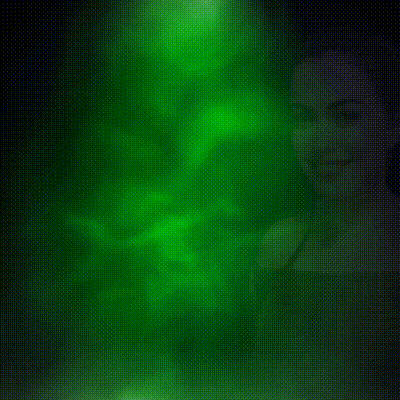 a woman in a green off the shoulder top smiles