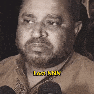 a man with a beard has lost nnn written on the bottom of his face
