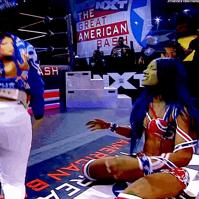 a woman in a wrestling outfit is sitting on the floor in front of a sign that says the great american bash