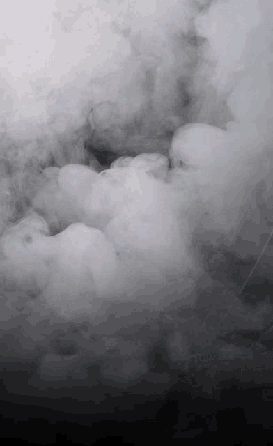a black and white photo of smoke coming out of a pipe